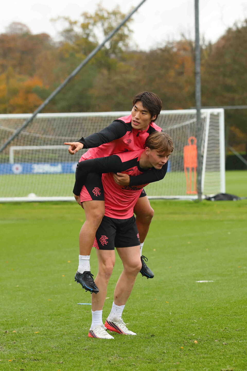 Two players training, one player lifts the other over his shoulder