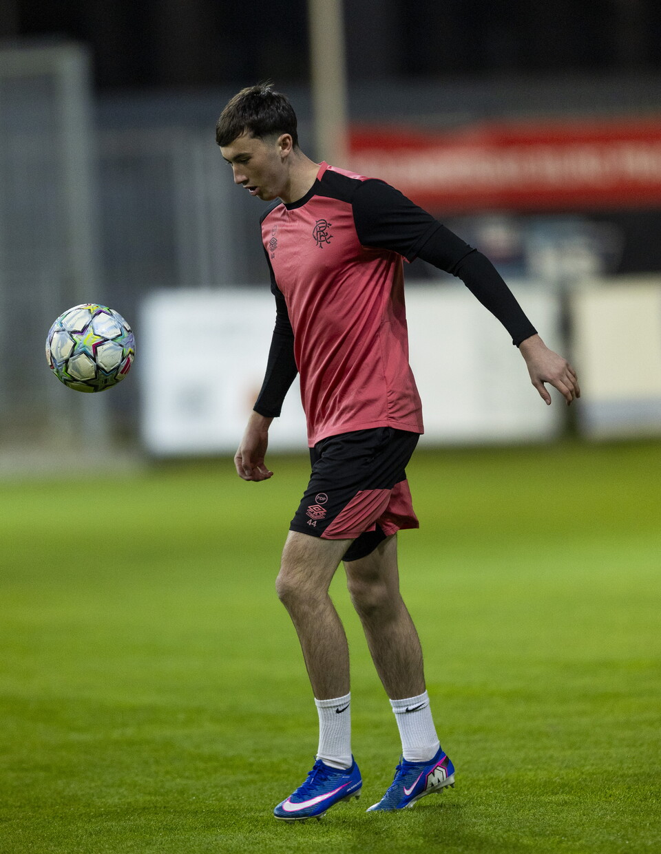 Footballer kicks ball high up in air during training session
