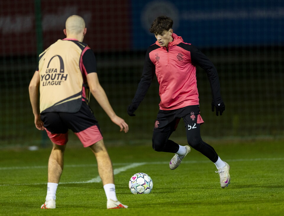 Two players training; one in yellow and one in pink, the latter running towards a soccer ball.