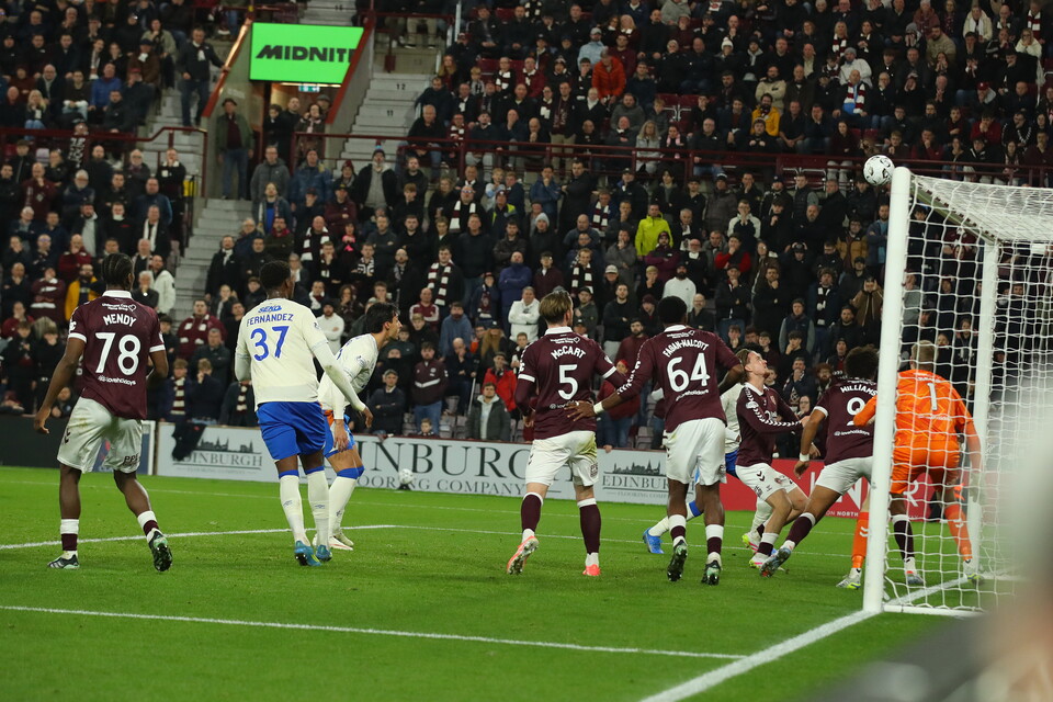 Soccer players in maroon and white uniforms on a green field.