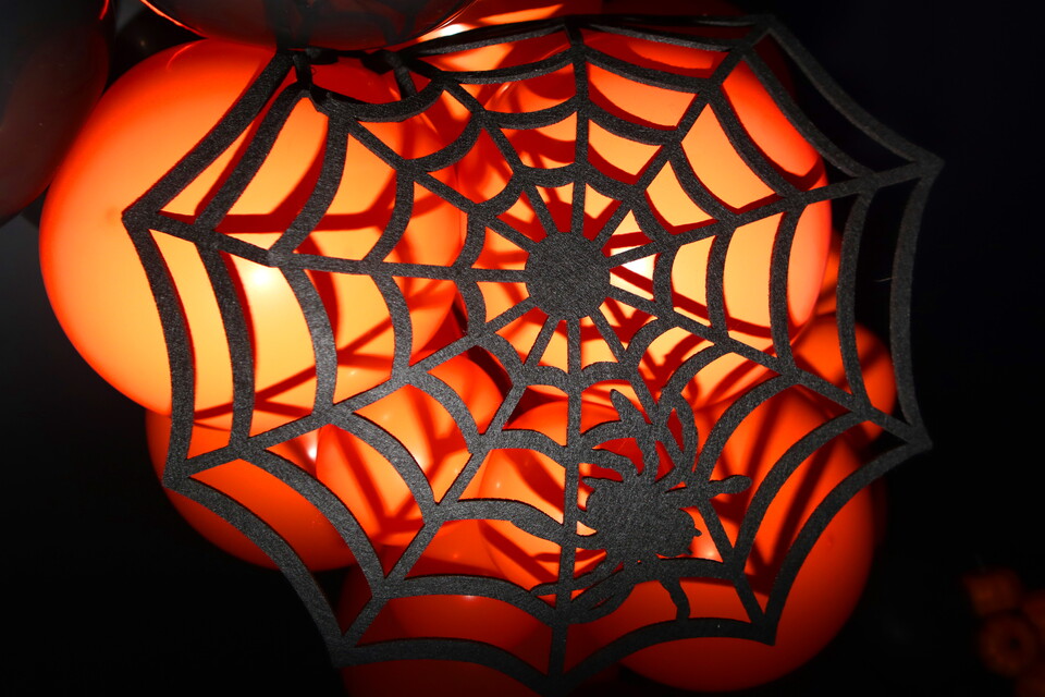 A spider web made of paper on a bright orange background.