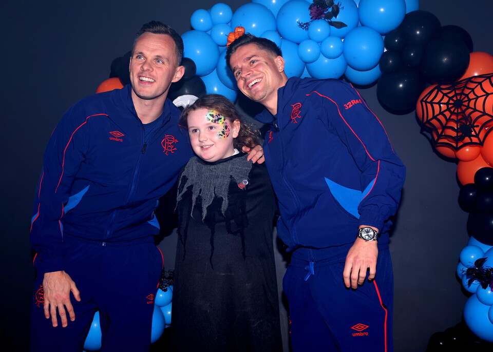 Two men and a young girl in Halloween costumes posing for a photo.