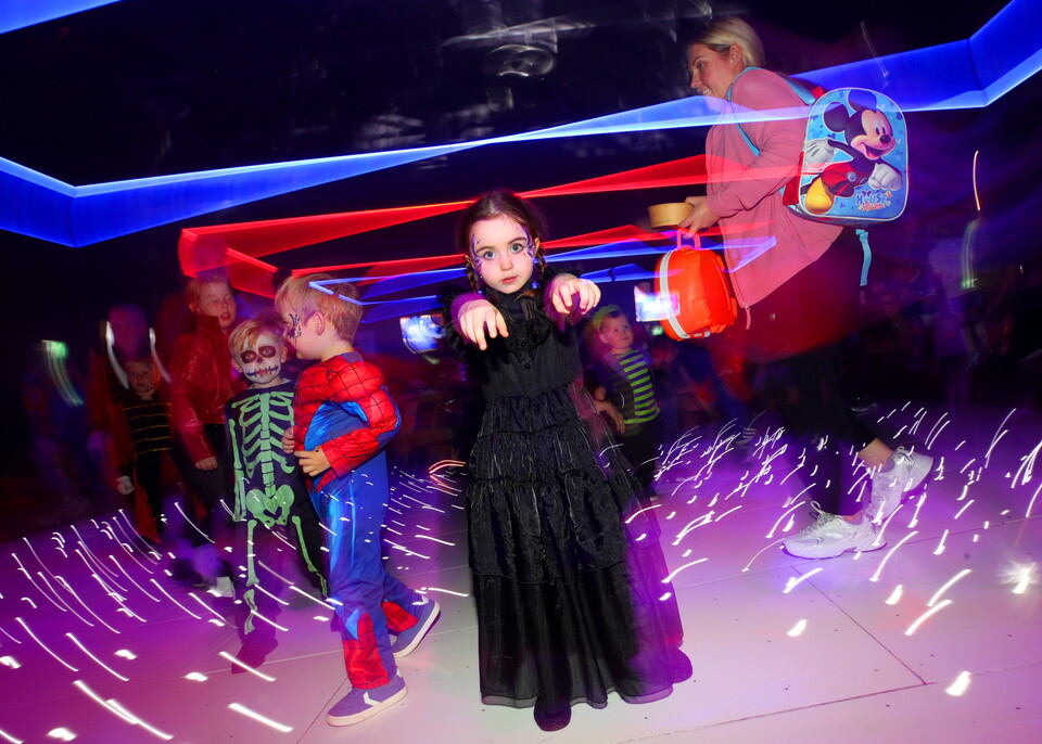 Girl in a Halloween costume dances under laser lights
