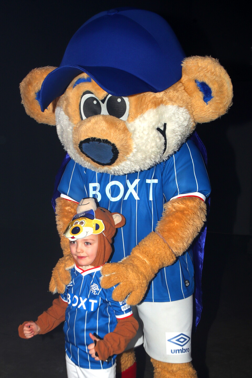 Mascot with child wearing football kit