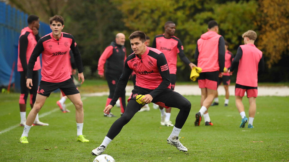 Soccer players wearing pink and black training suits on a field