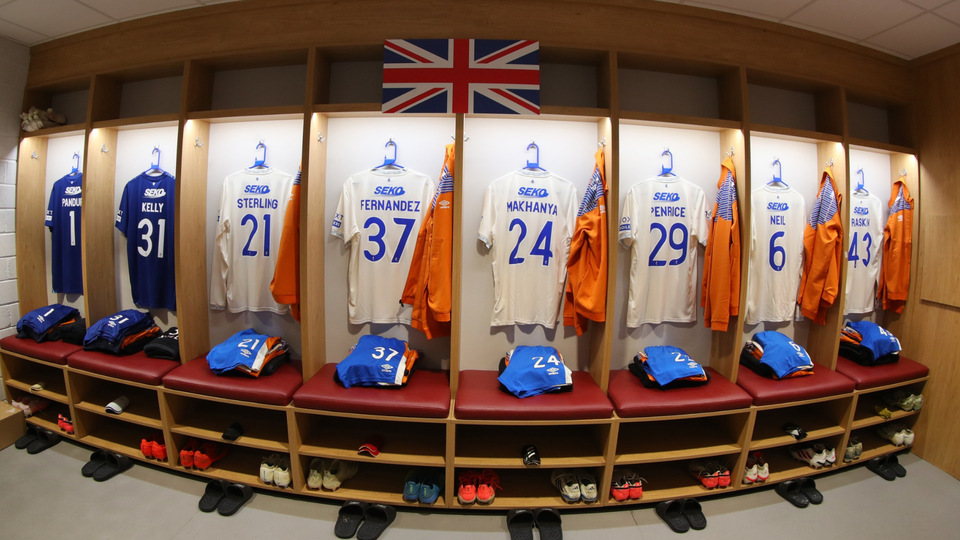 Locker room with blue and orange jerseys numbered 31, 21, 37, 24, 29, 6, and 43.